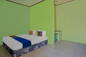 Postel nebo postele na pokoji v ubytování SPOT ON 92669 Guesthouse Prima SyariahNearGPdI Anugerah + 19 fotografií