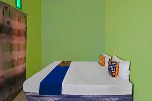 Postel nebo postele na pokoji v ubytování SPOT ON 92669 Guesthouse Prima SyariahNearGPdI Anugerah