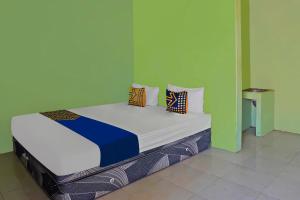 Postel nebo postele na pokoji v ubytování SPOT ON 92669 Guesthouse Prima SyariahNearGPdI Anugerah