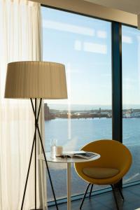 a table and a chair in a room with a window at Pullman Liverpool in Liverpool