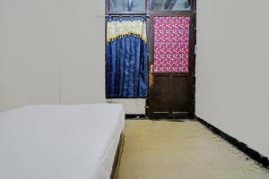 a room with a bed and two doors with curtains at OYO Life 92709 Kost Teras Cikapundung Syariah in Bandung
