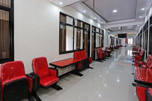 a waiting room with red chairs and windows at Hotel O Tjokro 3 in Bogor