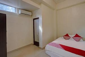 a bedroom with two beds and a window at Hotel O Octav Homestay in Nagoya
