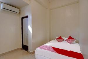 a bedroom with a bed with red and white pillows at Hotel O Octav Homestay in Nagoya