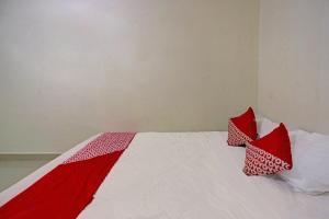a bed with red and white pillows on it at Hotel O Octav Homestay in Nagoya +18 photos