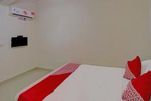 a bedroom with a bed with red and white sheets at Hotel O Octav Homestay in Nagoya