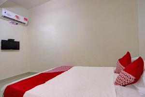 a bedroom with a bed with red pillows on it at Hotel O Octav Homestay in Nagoya