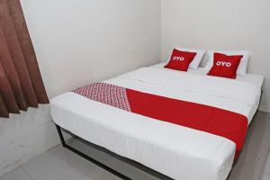a bed in a room with two red pillows at Hotel O Tjokro 3 in Bogor