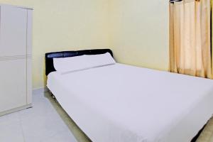 a bedroom with two beds in a room at Hotel O Kos Moncok in Tjakranegara +18 photos