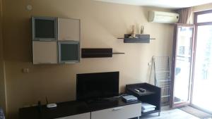 sala de estar con TV de pantalla plana en la pared en Krassy summer apartment, en Golden Sands