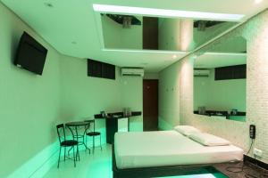 a hospital room with a bed and a table and chairs at Drops Motel Goiânia in Goiânia