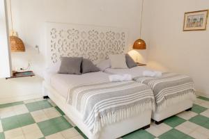 a white bed with two pillows on it in a room at Casa Guerrero in Cartagena de Indias