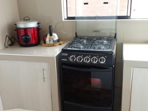 a kitchen with a black stove and a red appliance at Casablanca beach in Los Órganos