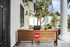 a laptop sitting on a bench outside a house at Hotel O Wisma Pundu Syariah Near Kantor Camat Kota Besi in Kotabesi