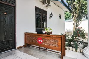 a desk with a stop sign on it in front of a house at Hotel O Wisma Pundu Syariah Near Kantor Camat Kota Besi in Kotabesi
