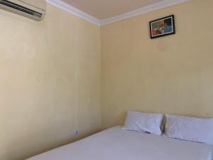 Postel nebo postele na pokoji v ubytování Hotel O Wisma Phinisi Syariah Near Mall of Pinrang Sejahtera + 12 fotografií