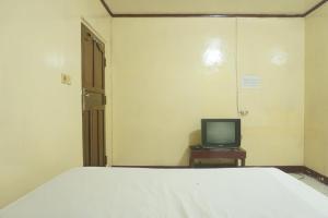 - une chambre avec un lit et une télévision sur une table dans l'établissement Hotel O Rumah Massagena Syariah Near Gedung Olahraga Enrekang, à Enrekang 17 autres photos