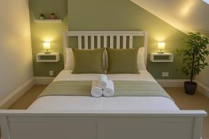 Un dormitorio con una cama con dos zapatos blancos. en Nestee Serviced Apartments - Central Torquay - Pet Friendly - Harbour Views, en Torquay