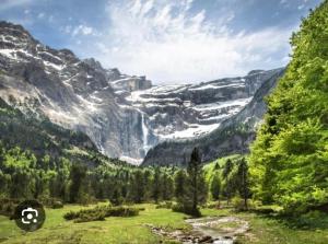 een uitzicht op een bergvallei met een waterval bij Charmant appartement in Argelès-Gazost