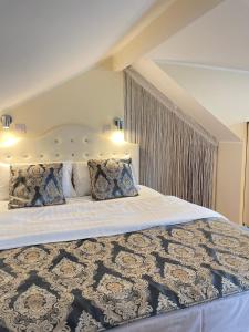 a bedroom with a large bed with white sheets and pillows at The White Lodge Hotel in Hereford