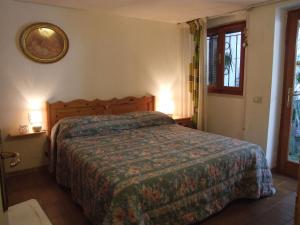 a bedroom with a bed and two lamps and a window at Cozy Holiday Home in Tuscany near wooded area in Castagneto Carducci