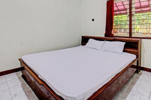 Ένα ή περισσότερα κρεβάτια σε δωμάτιο στο Hotel O Losmen Tjabe Merah Near Alfamart Bintaro
