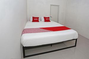 a bed in a room with red pillows on it at Hotel O Tjokro 3 in Bogor