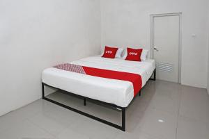 a bedroom with a large bed with red pillows at Hotel O Tjokro 3 in Bogor