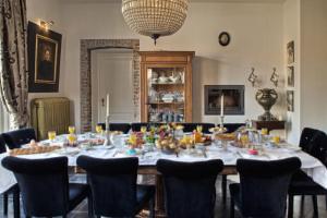 uma sala de jantar com uma grande mesa com cadeiras em B&B Domaine Villa Bayard em Kanne