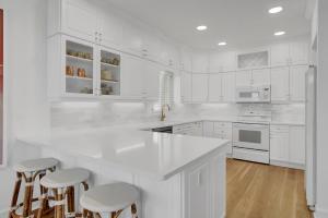 una cocina blanca con armarios blancos y taburetes de bar en Yacht Harbor Court 30 by Wild Dunes, Marina View with Resort Amenity Access, en Isle of Palms 51 fotos más