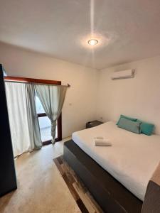 a bedroom with a large bed and a window at Casa Coral Pueblito - Self Check In in Mahahual +10 photos