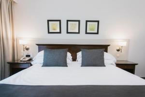 ein Schlafzimmer mit einem großen weißen Bett und zwei Kissen in der Unterkunft Hotel Dos Reyes in Mar del Plata