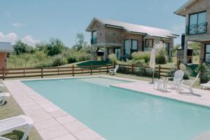 a swimming pool in front of a house at Pentagrama, casas de campo in Villa General Belgrano