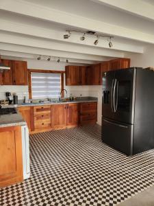 a kitchen with a black refrigerator and wooden cabinets at Viña Le Vigneron in Población +9 photos