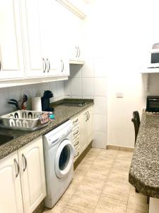 a kitchen with a sink and a washing machine at Comfort in Playa las Americas in Playa de las Americas