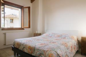 a bed in a room with a window and a bedspread at Casali Magnis in Remanzacco +2 photos