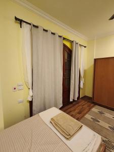 a bedroom with a bed and a window with curtains at Tunis Vista in Tunis