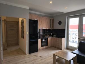 a kitchen with black appliances and a table in a room at Apartament ZARA Self Check In in Rzeszów
