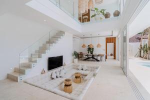 ein Wohnzimmer mit einer weißen Couch und einer Treppe in der Unterkunft Casa Auma Stunning 4 Bedroom Villa in Canggu in Tumbak Bayuh