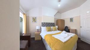 a bedroom with a large bed with a yellow blanket at Havana Lodge in Elswick