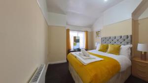 a bedroom with a large bed with a yellow blanket at Havana Lodge in Elswick