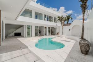 ein großes weißes Haus mit einem Pool in der Unterkunft Casa Auma Stunning 4 Bedroom Villa in Canggu in Tumbak Bayuh