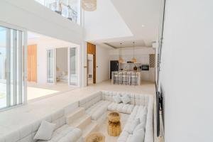 ein weißes Wohnzimmer mit einem großen weißen Sofa in der Unterkunft Casa Auma Stunning 4 Bedroom Villa in Canggu in Tumbak Bayuh