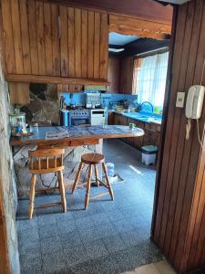 a kitchen with a large wooden table and two stools at Rosa 7 in Mercedes +16 photos