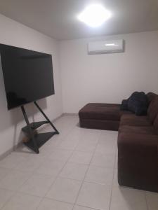 a living room with a couch and a flat screen tv at Decina in Mexicali +15 photos