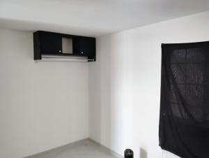 a white room with a black object on the wall at Decina in Mexicali