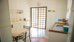 a kitchen with a table and a table and a sink at Casa com Piscina e Lazer Completo em Barra Bonita in Igarassú