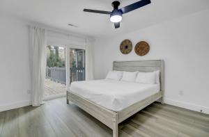 Un dormitorio blanco con una cama y un ventilador de techo. en Edgewater Alley 9 by Wild Dunes, with Amenities, en Isle of Palms