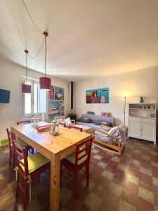 een woonkamer met een houten tafel en een bank bij Nura's - Il Balcone sui Tetti in Alghero +13 foto's