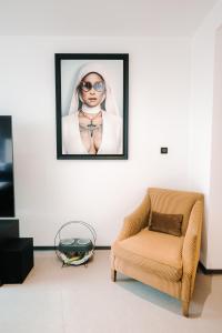 a living room with a chair and a picture on the wall at Grand appartement rez de jardin in Guebwiller